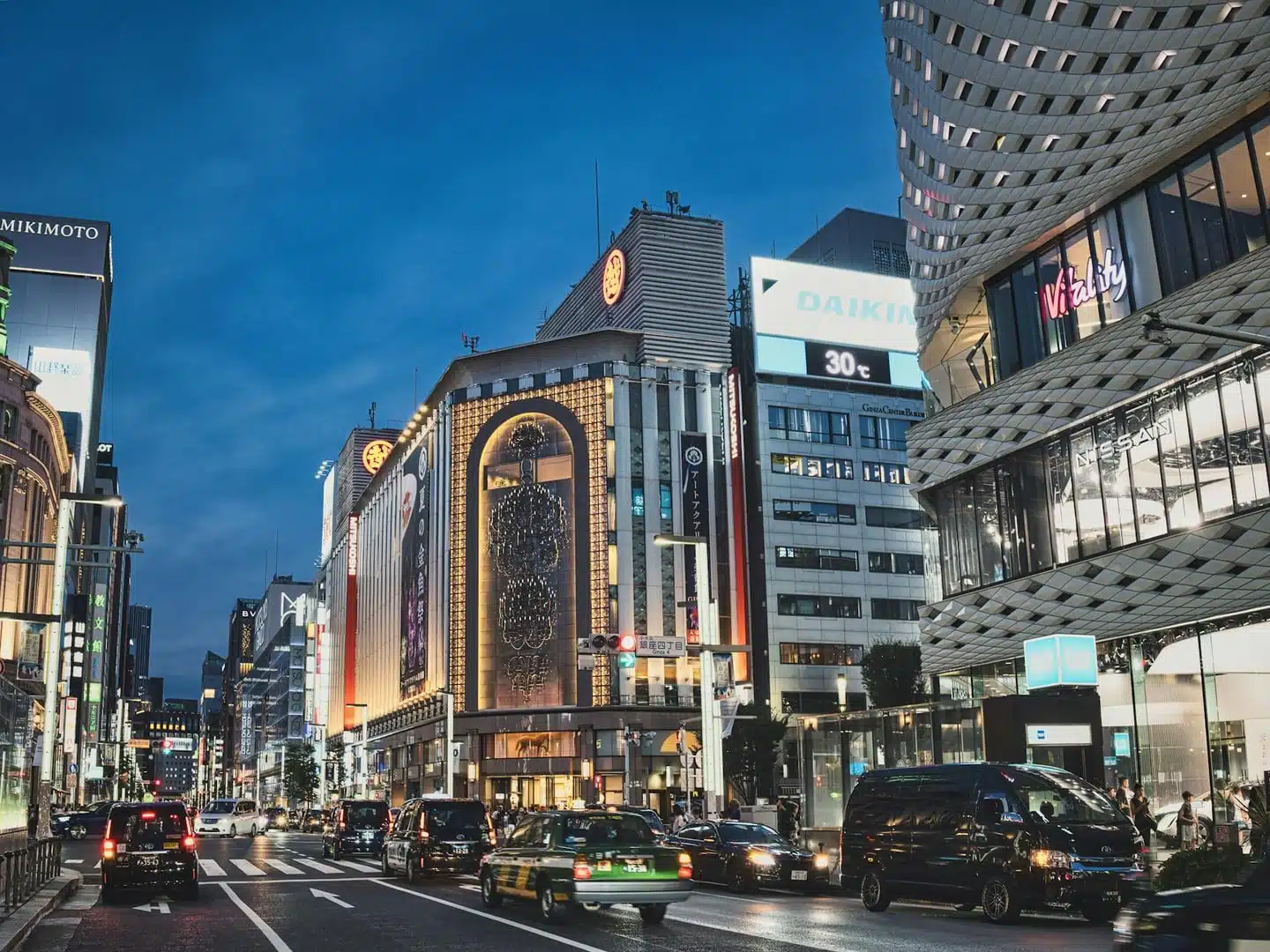 A bustling evening view of the famous Ginza district in Tokyo, showcasing vibrant city life and architecture.