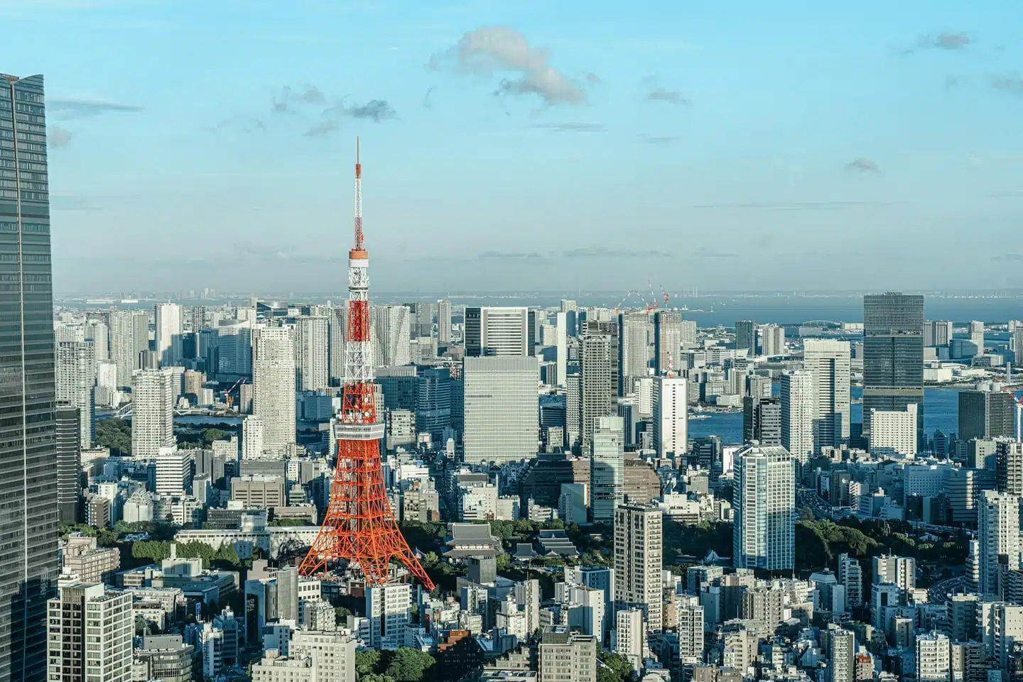 Elevated view of Tokyo cityscape with the iconic Tokyo Tower under a clear blue sky.