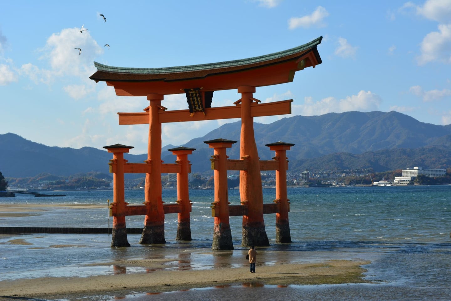 The majestic Torii gate at Itsukushima Shrine stands against a scenic backdrop in Miyajima, Japan.