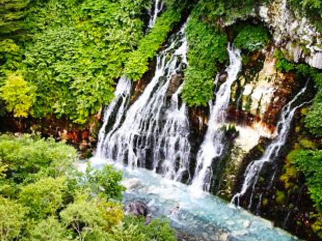 白鬚瀑布自岩壁滲流而下匯入湛藍溪流