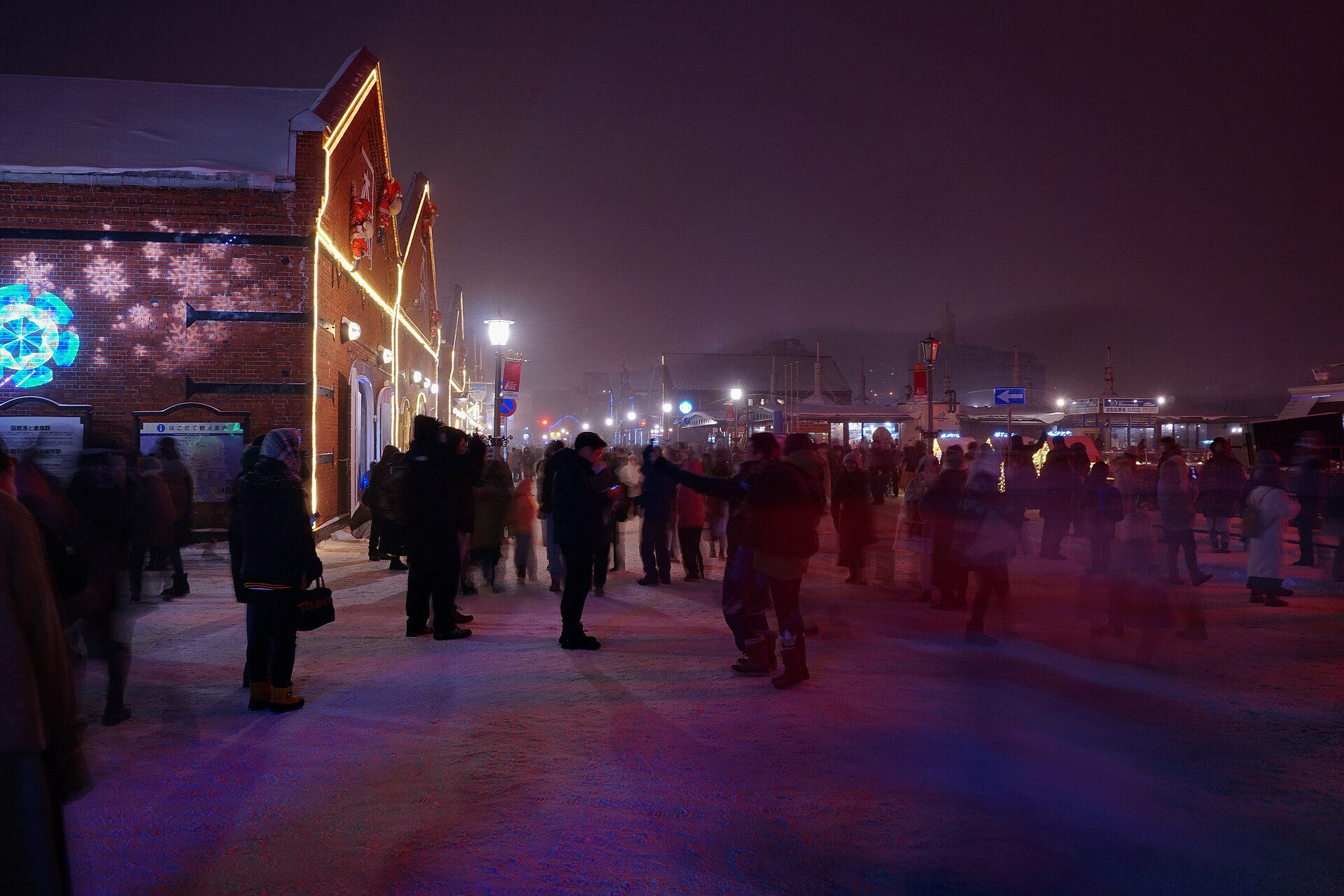 Crowds on the red brick warehouse main street at night during Christmas Fantasy