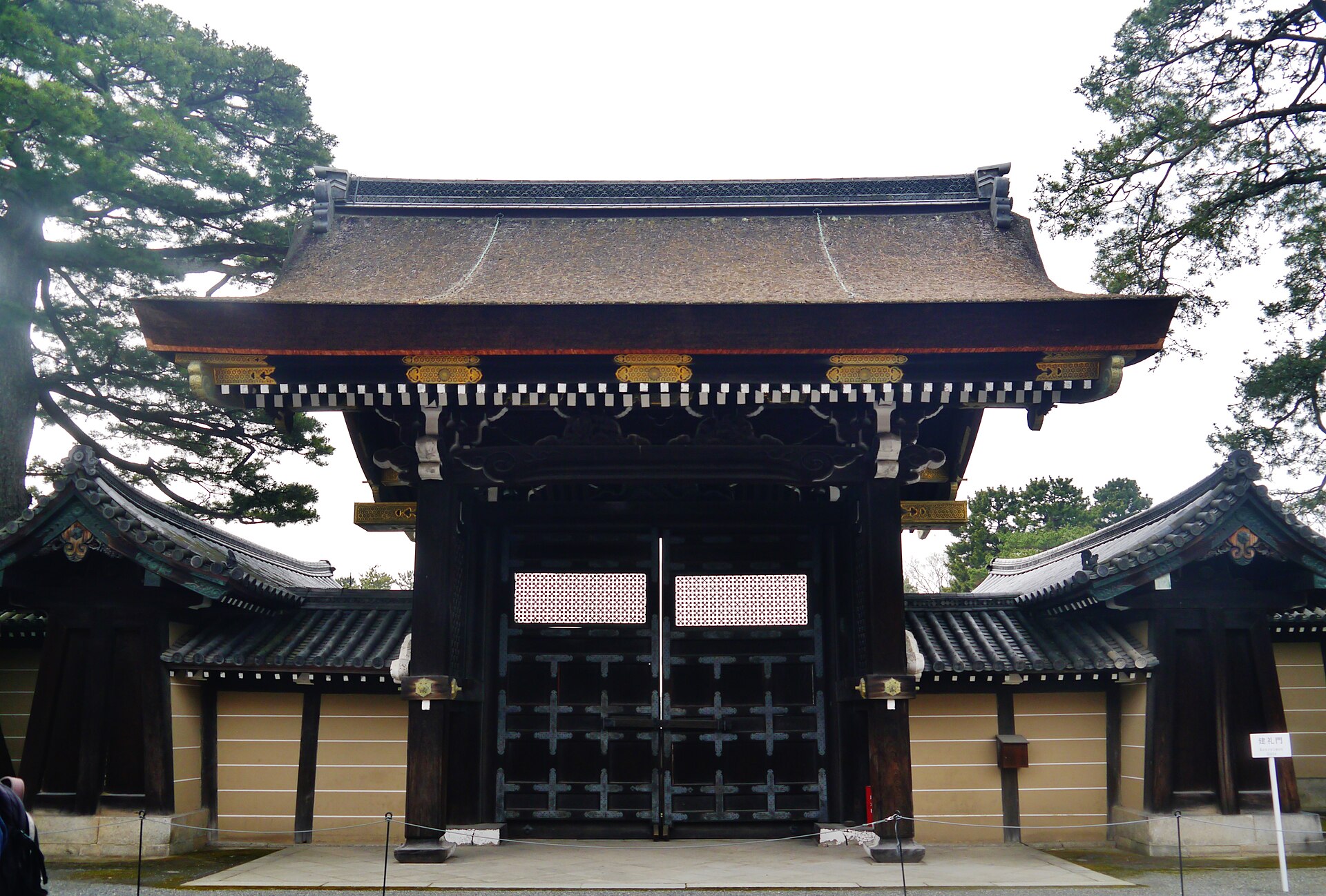 京都御所の建礼門。黒い木製の扉と瓦屋根、両側の白壁と松の木